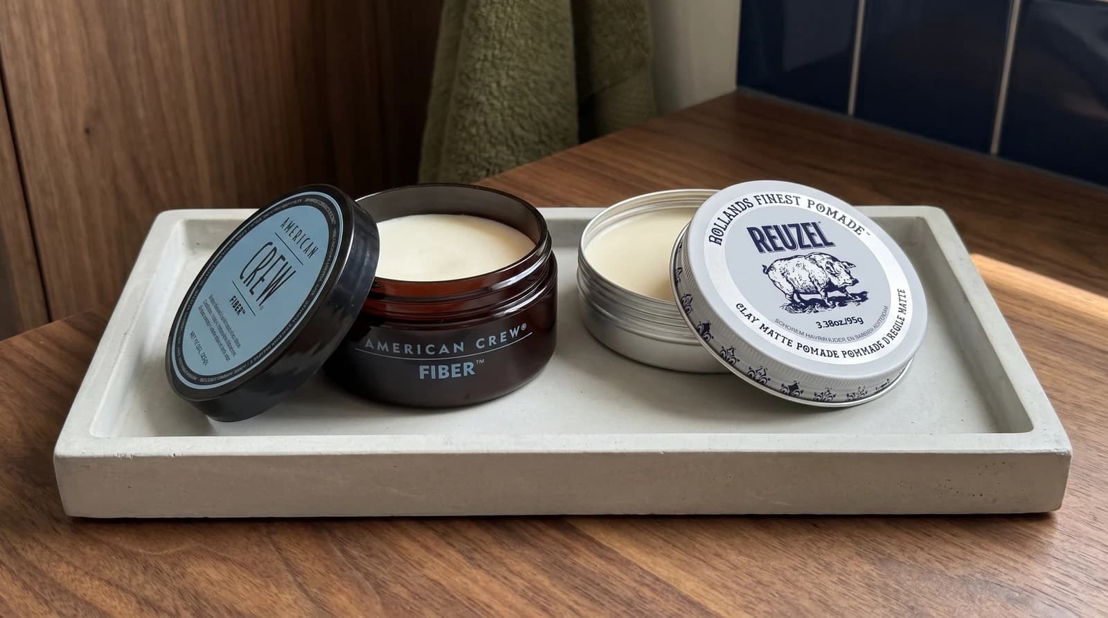 American Crew Fiber 85g and Reuzel Clay Matte 95g on a dressing table