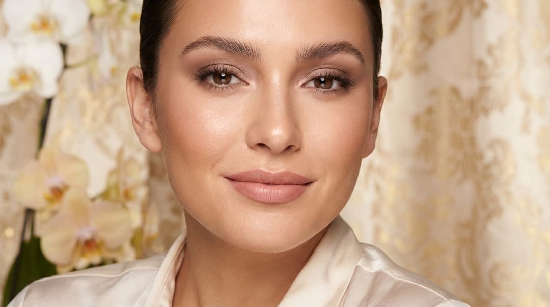 Close-up of a woman wearing polished soft glam makeup with glowing skin