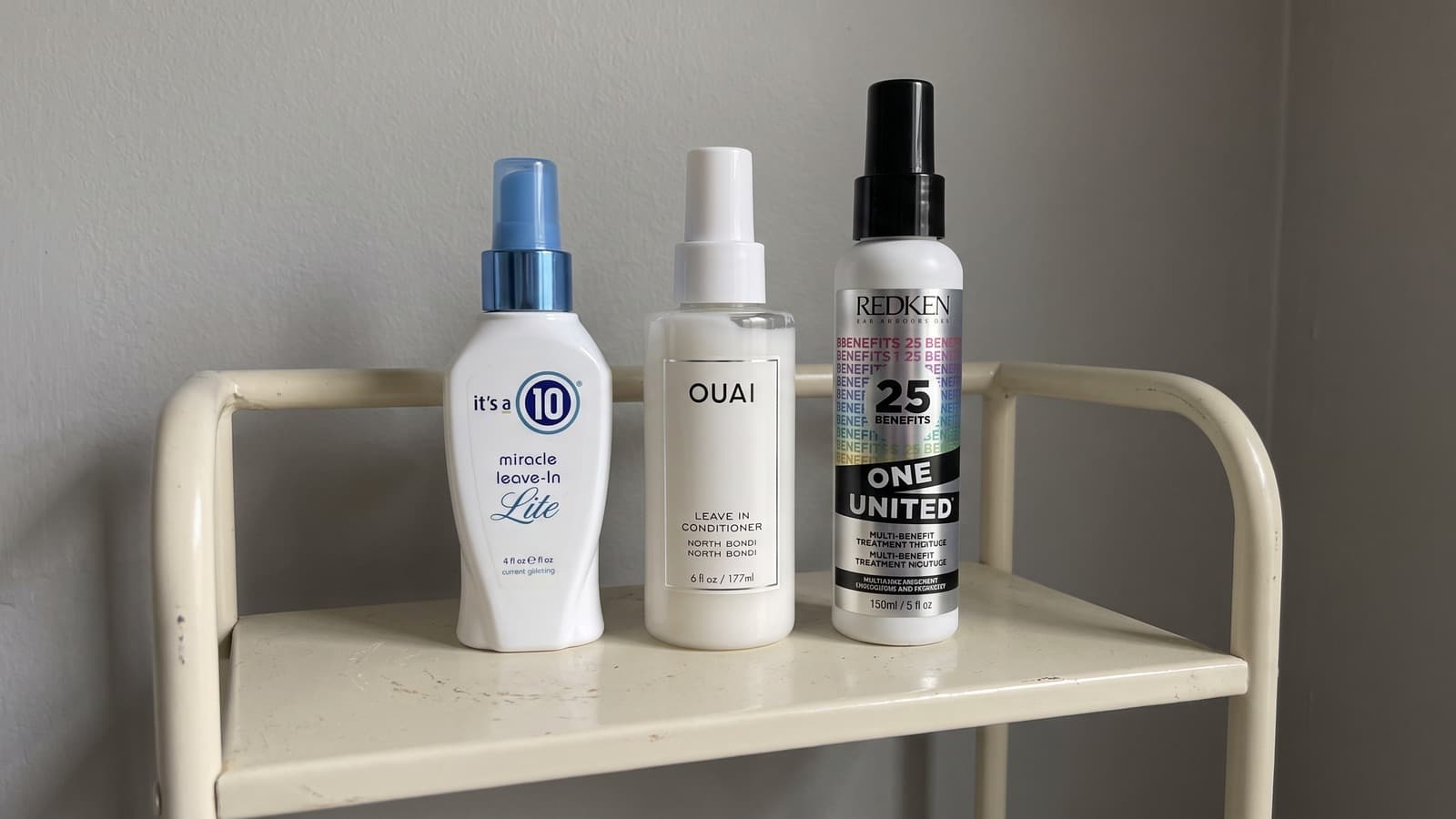 It’s a 10 Lite, OUAI North Bondi and Redken One United leave-in conditioners on a cream shelf