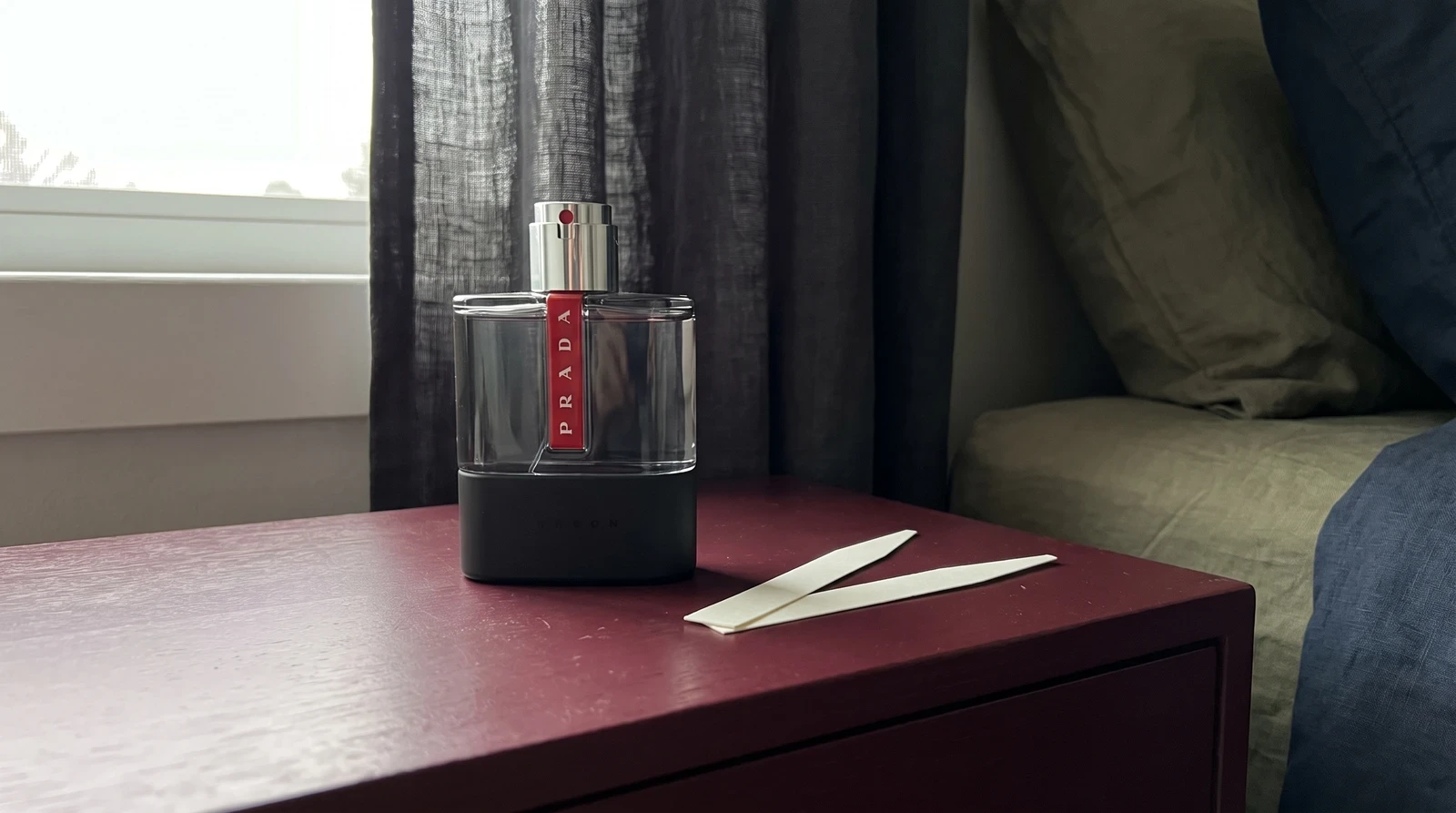 Prada Luna Rossa Carbon beside paper scent strips